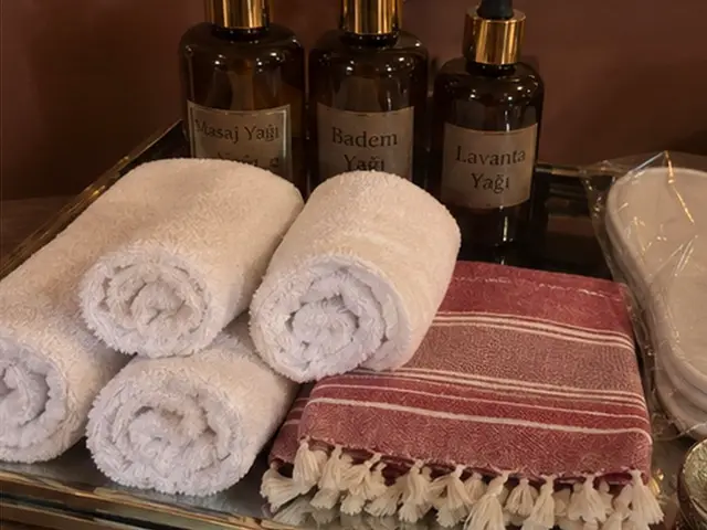 Masaj yağları, rulo havlular, kırmızı çizgili peştemal ve terlik — Çiftlikköy, Masaj Salonun